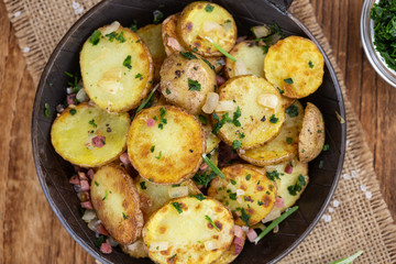 Portion of Fried Potatoes on an old wooden table (selective focus; close-up)