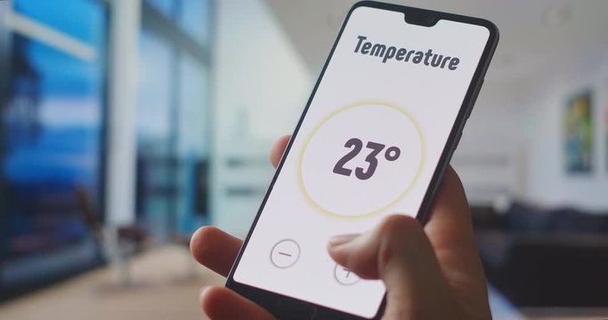 Home automation and remote control. Internet things and modern smart technology. Young Handsome Man Gives Command to a Smart Home Application on His Smartphone. Using smart home app on digital device