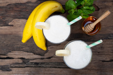 Banana fresh cocktail vanilla smoothies  fruit juice beverage healthy the taste yummy in glass drink episode good morning on wooden background from the top view.
