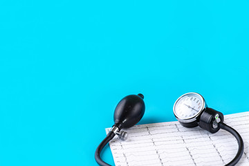 Tonometer, device for measuring blood pressure, cardiogram on a blue background. Close up. Place to insert text. Copy space