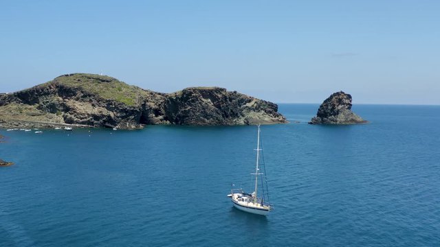 The sea of ​​Pantelleria with its jagged and volcanic coast. Turquoise colored sea. Dammusi, typical houses of Pantelleria.