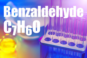 The inscription Benzaldehyde and its formula on the background of chemical test tubes. The use of...