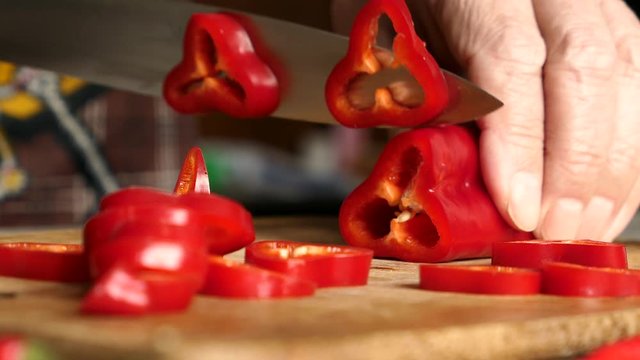 Using Knife To Cutting Ramiro Red Hot Pepper On Cutting Wooden Board. Top View. Panning Slider Shot. Close Up..