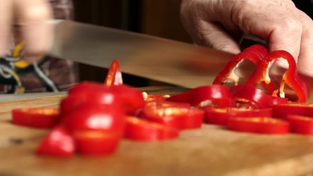 Using Knife To Cutting Ramiro Red Hot Pepper On Cutting Wooden Board. Top View. Panning Slider Shot. Close Up..