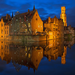 Obraz premium Square cityscape reflection of Bruges with its belfry and canals at night during the blue hour, Belgium. 