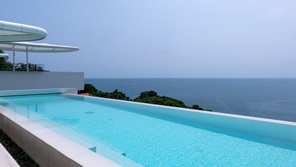 Swimming pool overlooking view andaman sea and clear sky background,summer holiday background concept.