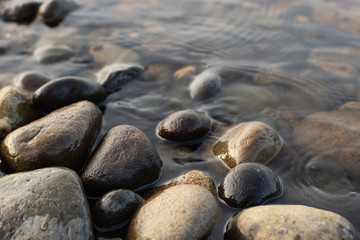 Fototapeta na wymiar Piedras hundidas en agua de un lago. 