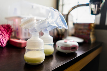 breast pump with mothers milk in the bottle, concept of parenthood motherhood bring up new born...