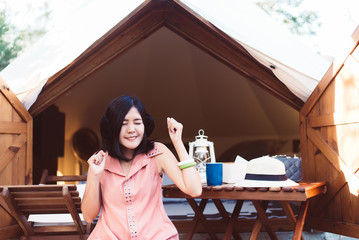 Beautiful asian woman sitting at tent in the morning,Enjoys of resting time,Happy and smiling