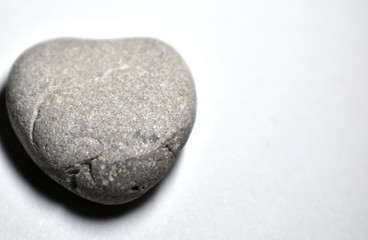 Heart-shaped sea stone (pebble) on white background isolated