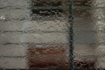 window is cleaned with water.Water is flowing on a window glass.Water splash droplet on a big glass surface.