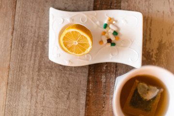 Top view of lemon, pills and tea on the table