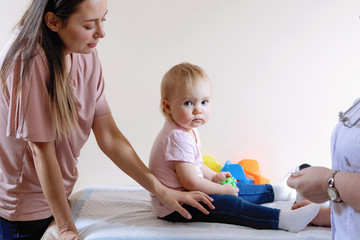 Children's doctor, mother, blonde girl in a medical clinic.