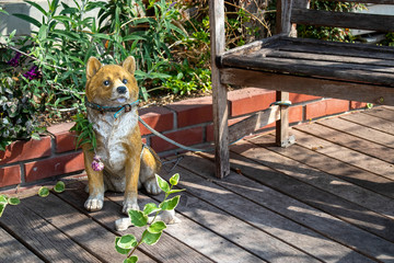 ウッドデッキの犬の置き物と木のベンチ