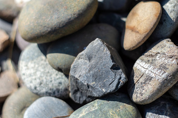 Small stones of different colors close up in sunlight