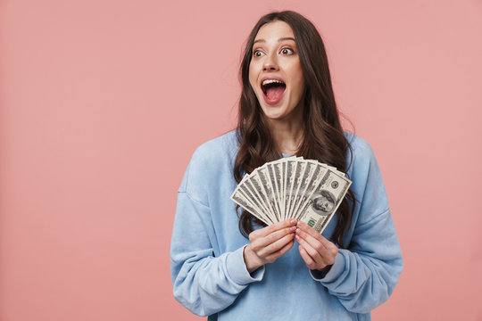 Image of attractive young woman rejoicing and holding dollar banknotes