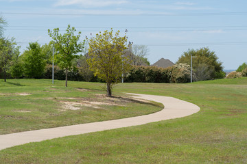 Concrete path of urban trail on a sunny spring day.