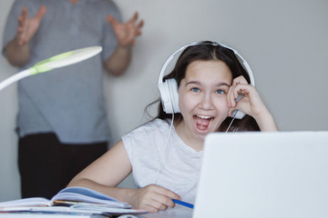 Teenager girl at a table with a white laptop.