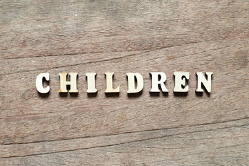 Letter block in word children on wood background