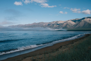 A body of water with a mountain in the background