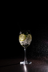 refreshing cocktail on a neutral black background with flying splashes in the air