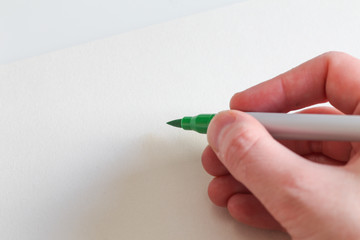 Close-up of a Green Markers Writing in a White Paper.