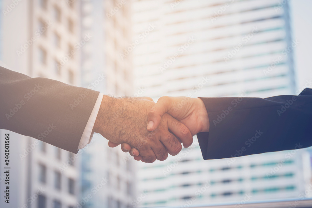 Wall mural Close up of business people shaking hands