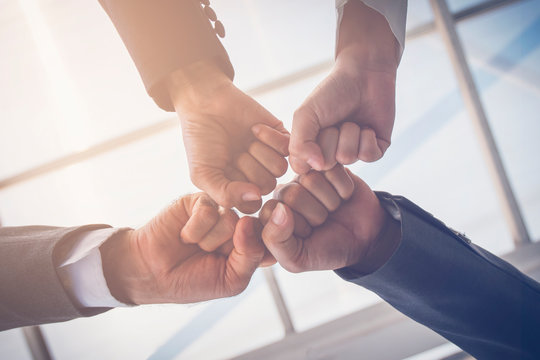 Close-up of a fist bump in vintage tone. Group hands of young people show strength teamwork. Business and teamwork concept.