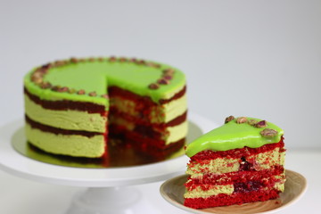 Raspberry cake with pistachio on a light background. red velvet cake. sliced dessert closeup