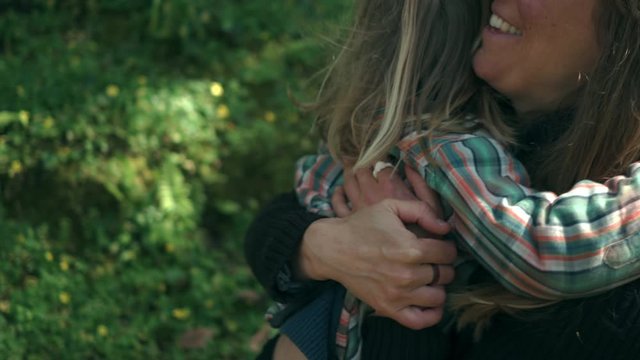 Little boy in woods running to embrace and kiss his mother