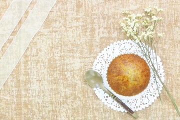 Close up single banana cup cake bakery top view on white doily paper with vintage olded spoon and flower look delicious on wooden table background have copy space.