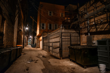 Fototapeta na wymiar Dark and eerie urban city alley at night 