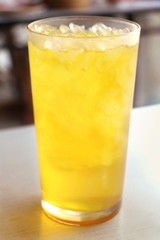 Close up isolated Chrysanthemum ice tea glass on table in chinese restaurant , yellow herbal water for drink will felling fresh in summer.