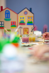 cardboard house on the background of multi-colored paints