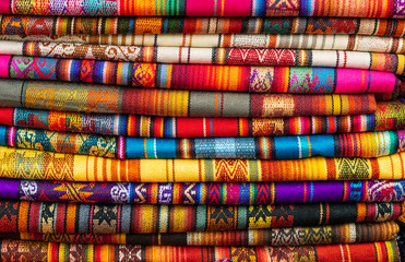 A pile of colorful Andean fabrics on the poncho market of Otavalo, Quito Region, Ecuador.