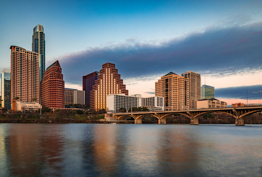 Downtown view across Lady Bird Lake or Town Lake on Colorado River at sunset golden hour in Austin, Texas, USA