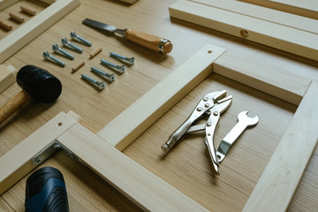 Top view of furniture assembly parts and wood work tools on wooden floor