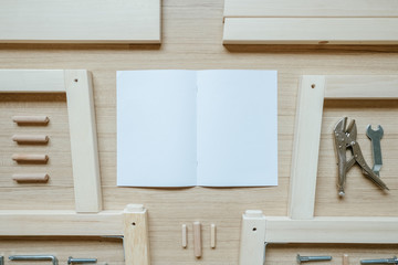 Top view of furniture assembly parts and tools on wooden floor for DIY do it yourself and assemble the work, blank space instruction paper to put logo