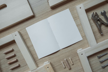 Top view of furniture assembly parts and tools on wooden floor with blank space paper