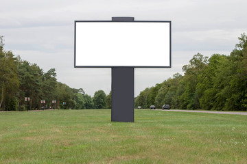 Blank white billboard for advertising on background of trees and sky. Place for text