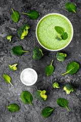 Broccoli and spinach cream soup on grey desk top view. Vegetable pattern