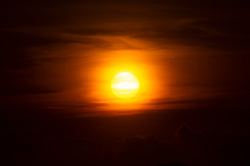 Obraz premium Big sun on Sunset sky with dark clouds.