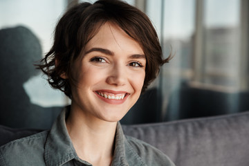 Image of brunette cute happy woman smiling and looking at camera