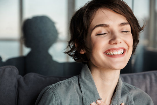 Image of brunette cute happy woman posing and laughing at camera