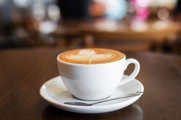 Hot art Latte coffee cup on wooden table in Coffee shop