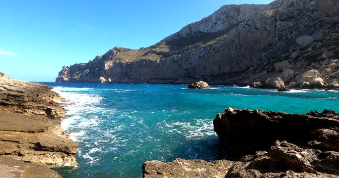 Waves hitting rocks on the coast of Mallorca, sunny day, in Balearic islands, Spain