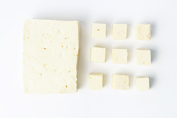 Whole tofu and sliced, white background, top view