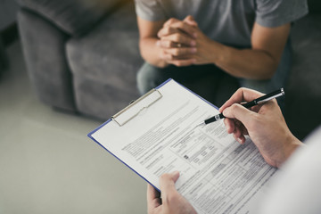 Doctor holding pen is checking the patient condition and is explaining the results of the examination to the patient listening at home.
