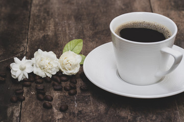 Obraz na płótnie Canvas Cup coffee and jasmine flower on old wooden plate.
