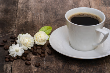 Obraz na płótnie Canvas Cup coffee and jasmine flower on old wooden plate.